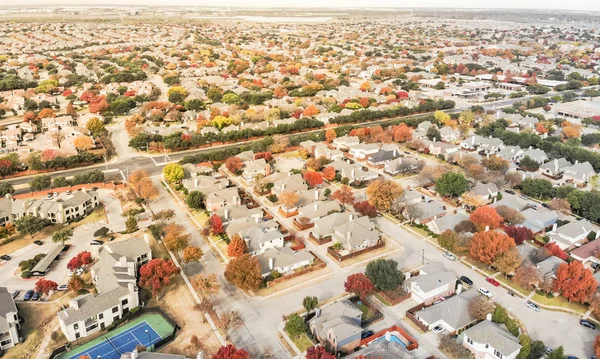 Aerial view Valley Ranch planned unit development with community tennis court in Dallas suburb of Irving, Texas, USA. Colorful fall foliage leaves, row of single-family homes, urban sprawl subdivision
