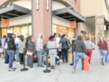 Moda siyah Cuma sırasında açık mağaza outlet alışveriş merkezi, Texas, ABD için girişinde bekleyen müşterinin soyut uzun çizgi bulanık. Ufuk tatil alışveriş arka plan, geri çekilebilir kemer desteklemek