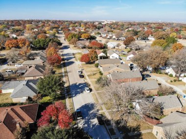 Üst sonbahar sezonu Coppell, Texas, ABD içinde güzel mahalle görüntüleyin. Satır ile tek aile ev garaj bağlı, tarafından renkli yaprakları yaprakları mavi gökyüzü altında Bahçe, çevrili düşmek