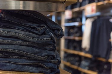 Sığ dof, elbise dükkanı raf raf ve alışveriş, arka planda tekstil ürünü seçmek bulanık müşteri trendy giyim ile seçici odak görüntü.