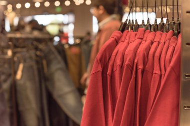 Seçici odak, elbise dükkanı askı ve alışveriş, arka planda tekstil ürünü seçmek bulanık müşteri trendy giyim ile sığ dof görüntü.