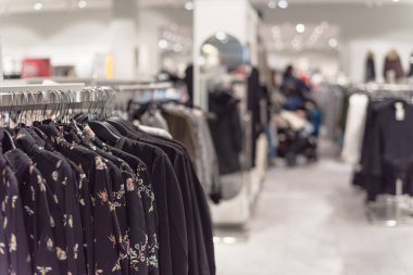 Seçici odak, elbise dükkanı askı ve alışveriş, arka planda tekstil ürünü seçmek bulanık müşteri trendy giyim ile sığ dof görüntü.