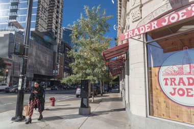 Chicago, IL, bize-Ekim 17, 2018: Müşteri kağıt bakkal çantası ile Chicago şehir merkezindeki işlek cadde yakınında Trader Joe's mağaza çıkın. Amerikalı özel düzenlenen özel Aldi tarafından kendi marketler zinciri