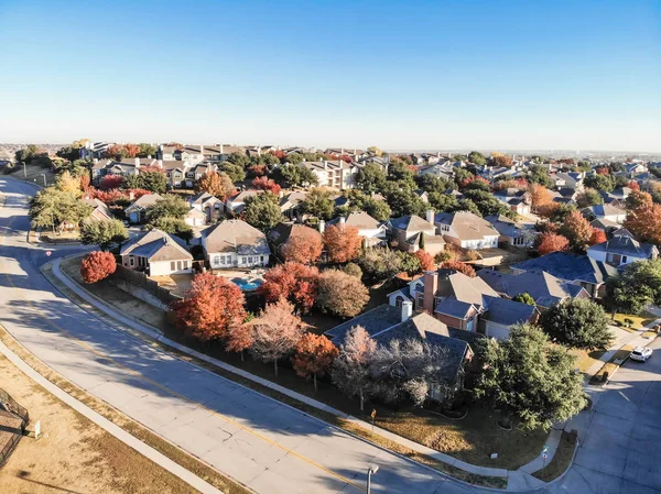 Top view planned unit development suburbs of Dallas, Texas, USA in autumn season. Picture from drone residential area with colorful fall foliage leaves under blue sky