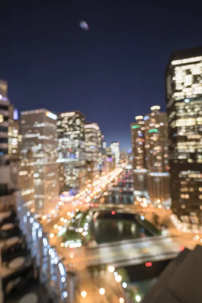 Abstract blurred defocused of Chicago riverside office and residential building high-rise. Aerial view urban night light bokeh from illuminated skylines