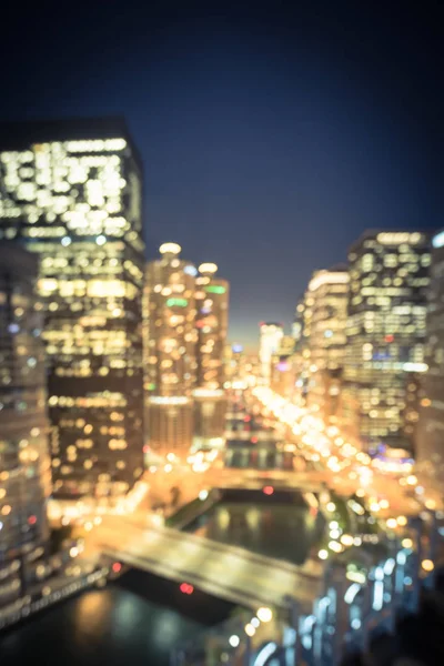 Vintage tone motion blurred defocused of Chicago riverside office and residential building high-rise. Aerial view urban night light bokeh from illuminated skylines