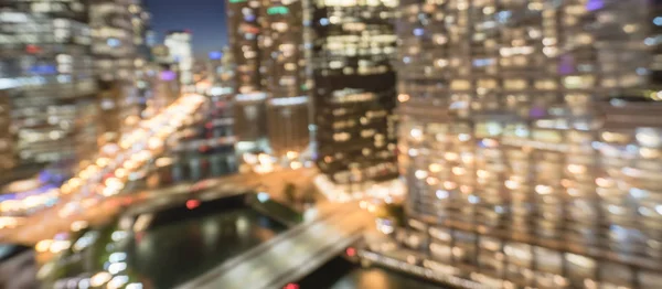 Panorama abstract blurred defocused of Chicago riverside office and residential building high-rise. Aerial view urban night light bokeh from illuminated skylines