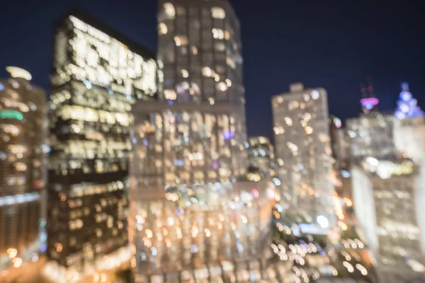 Abstract blurred defocused of Chicago riverside office and residential building high-rise. Aerial view urban night light bokeh from illuminated skylines