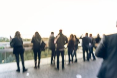 Vintage tone blurred image diverse group of people in formal dress hanging out at rooftop bar in downtown Chicago, USA. Business happy hour concept, autumn season