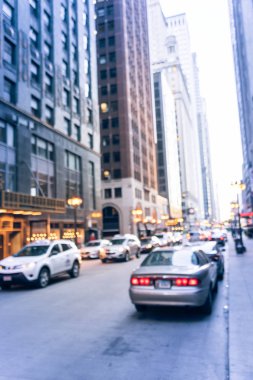 Bulanık meşgul sokak dar sokakta batımında Chicago şehir merkezine. Ufuk bokeh sokakta araçların uzun satırından ışık