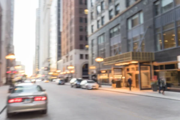 Blurred busy street alley in downtown Chicago at sunset. Defocused bokeh light from long line of cars on street