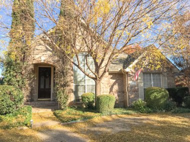 Renkli sonbahar yaprakları ve Dallas, Texas, Usa yakınındaki Amerikan bayrağı ile tek aile evi tipik ön sundurma giriş