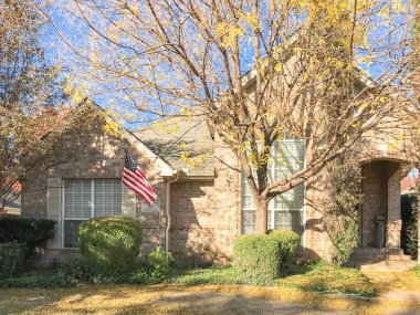 Renkli sonbahar yaprakları ve Dallas, Texas, Usa yakınındaki Amerikan bayrağı ile tek aile evi tipik ön sundurma giriş