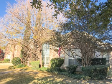Renkli sonbahar yaprakları ve Dallas, Texas, Usa yakınındaki Amerikan bayrağı ile tek aile evi tipik ön sundurma giriş