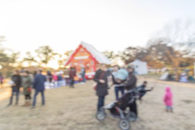 Zıplayan ev ve üst ve Gingerbread Jubilee, Noel Kış Festivali yakın yerleşim bölgesinde varoşlarda Dallas, Texas, ABD Genel park, sıraya queuing çocuklar soyut bulanık