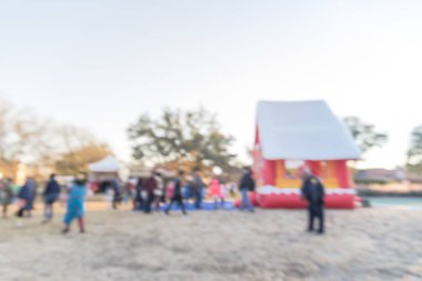 Zıplayan ev ve üst ve Gingerbread Jubilee, Noel Kış Festivali yakın yerleşim bölgesinde varoşlarda Dallas, Texas, ABD Genel park, sıraya queuing çocuklar soyut bulanık