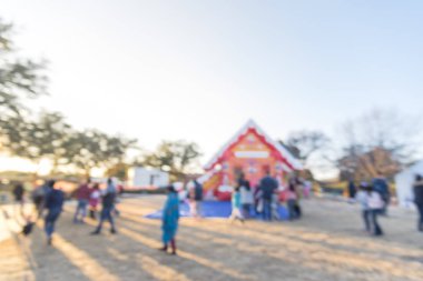 Zıplayan ev ve üst ve Gingerbread Jubilee, Noel Kış Festivali yakın yerleşim bölgesinde varoşlarda Dallas, Texas, ABD Genel park, sıraya queuing çocuklar soyut bulanık