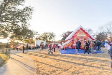 Zıplayan ev ve üst ve Gingerbread Jubilee, Noel Kış Festivali yakın yerleşim bölgesinde varoşlarda Dallas, Texas, ABD Genel park, sıraya queuing çocuklar soyut bulanık
