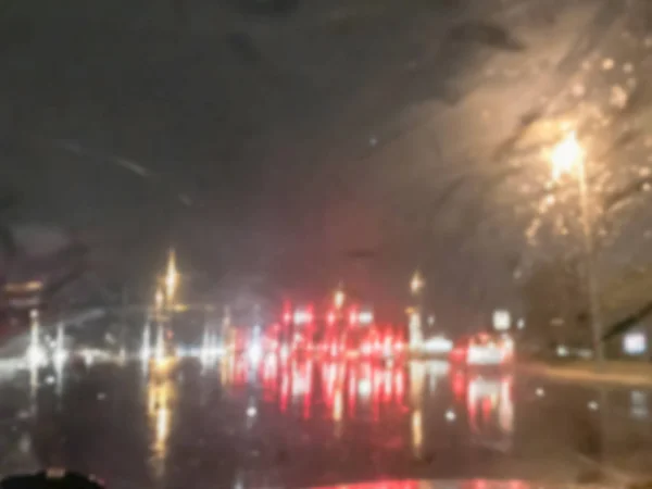 ぼやけ抽象は 雨のアスファルトの道路の信号交差点とリアのライトの反射で車を停止します アメリカで多重の景観や交通の背景 — ストック写真