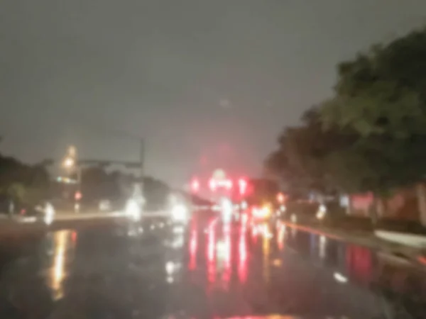 ぼやけ抽象は 雨のアスファルトの道路の信号交差点とリアのライトの反射で車を停止します アメリカで多重の景観や交通の背景 — ストック写真