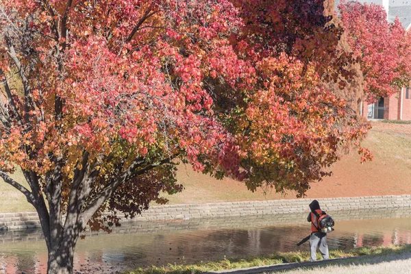 Неизвестный Мужчина Воздуходувом Очищает Опавшие Осенние Листья Возле Жилого Комплекса — стоковое фото
