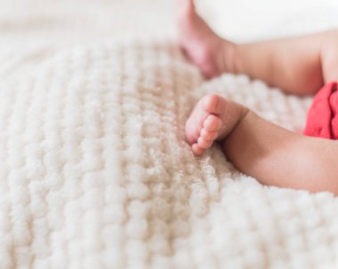 Yakın çekim yeni doğan bebek çocuk ayakları rahat battaniye arka plan üzerinde