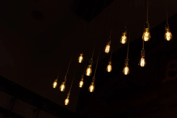 Close Set Vintage Glowing Light Bulbs Hanging Black Background Decorative — Stock Photo, Image