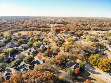 Havadan görünümü semtte yayılma alt arka plan ile. Renkli sonbahar yaprakları çiçek Höyük, Texas, ABD, mavi gökyüzü ile Köprü tek aile evleri