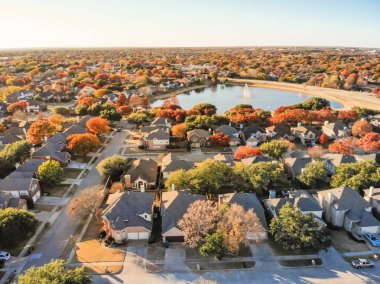 Havadan görünümü lakeside renkli sonbahar yaprakları ile mahalle ev sahipliği yapmaktadır. Üstgeçidin satır yakın göl su çeşme çiçek Höyük, Texas, ABD ile ekli garaj ile tek ailelik evlerin