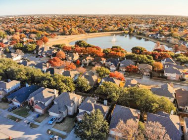 Havadan görünümü lakeside renkli sonbahar yaprakları ile mahalle ev sahipliği yapmaktadır. Üstgeçidin satır yakın göl su çeşme çiçek Höyük, Texas, ABD ile ekli garaj ile tek ailelik evlerin