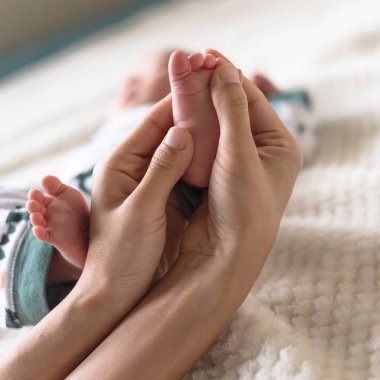 Asya bebek anne elinde küçük parmakları. Sevgi ve koruma kavramı