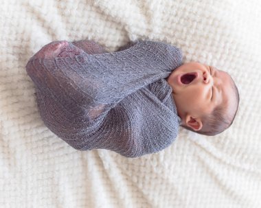 Mor örme tiftik şal giysili Asya bebek çocuk. 6 gün eski bebek yatakta rahat battaniye arka plan ile yatıyordu güzel portresi