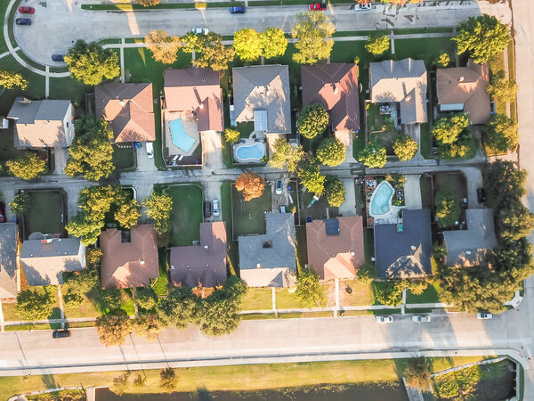 Top view residential neighborhood with cul-de-sac (dead-end) in Carrollton, Texas, USA in autumn sunset. Row of tightly packaged home with swimming pool, garden, driveway and attached garage