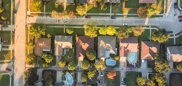 Panoramic top view residential neighborhood with cul-de-sac (dead-end) in Carrollton, Texas, USA in autumn sunset. Row of tightly packaged home with swimming pool, garden, driveway, attached garage