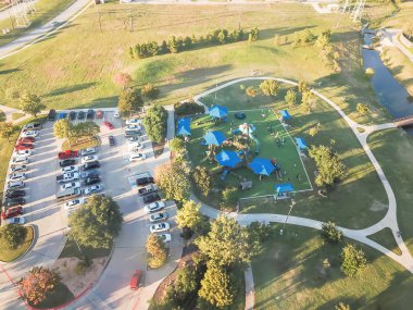Üstten görünüm oyun alanında Carrollton, varoşlarda Dallas, Texas, ABD creek ve köprü ile büyük park yakınındaki. Üstten görünüm eğlence yeşil alan oldukça büyük sentetik çim Bahçesi ve kapalı piknik spot ile