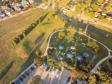 Üstten görünüm Bahçesi havai güç hatlarında Carrollton, varoşlarda Dallas, Texas, ABD ile konut mahalle yakın. Eğlence yeşil alan oldukça büyük sentetik çim, kapalı piknik günbatımında spot