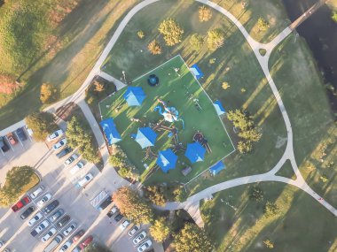 Üstten görünüm oyun alanında Carrollton, varoşlarda Dallas, Texas, ABD creek ve köprü ile büyük park yakınındaki. Üstten görünüm eğlence yeşil alan oldukça büyük sentetik çim Bahçesi ve kapalı piknik spot ile