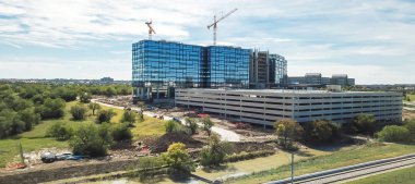 Panorama üstten görünüm çalışma vinç yakınındaki demiryolu parça inşaat sahasında. Yeni kurumsal yapı yüksek katlı ve çok düzeyli garaj Park