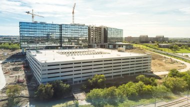 Panorama üstten görünüm çalışma vinç yakınındaki demiryolu parça inşaat sahasında. Yeni kurumsal yapı yüksek katlı ve çok düzeyli garaj Park