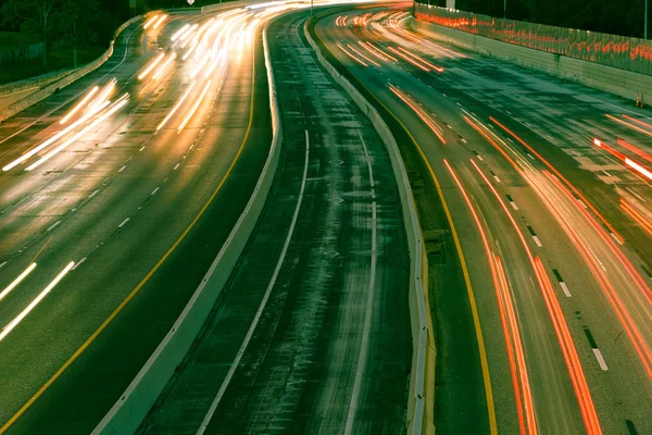 Vintage tone long-exposure over a highway with high-occupancy vehicle (HOV, carpool, diamond) lane in downtown Dallas, Texas, USA. Night highway with long exposure car trail lights