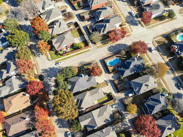 Top view residential houses with swimming pool and colorful fall foliage suburban Dallas, Texas, USA. Straight down look as satellite style.