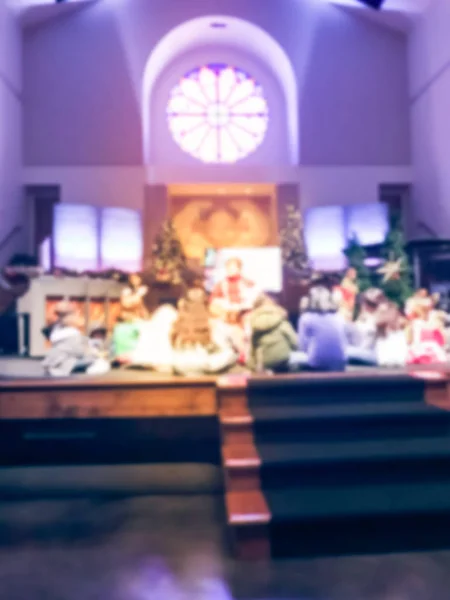 Blurred abstract story time for children on church stage during Christmas Eve service in America