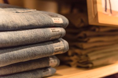 Amerika'da store kot giyim, yakın çekim yumuşak odak yığını. Şık denim Konfeksiyon, gündelik elbise tarzı mağaza raf raf