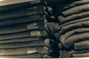 Amerika'da store kot giyim, yakın çekim yumuşak odak yığını. Şık denim Konfeksiyon, gündelik elbise tarzı mağaza raf raf