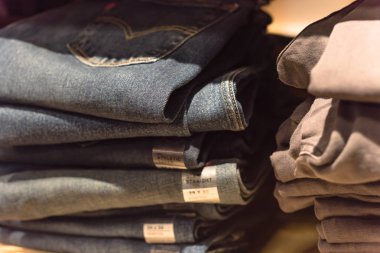 Amerika'da store kot giyim, yakın çekim yumuşak odak yığını. Şık denim Konfeksiyon, gündelik elbise tarzı mağaza raf raf