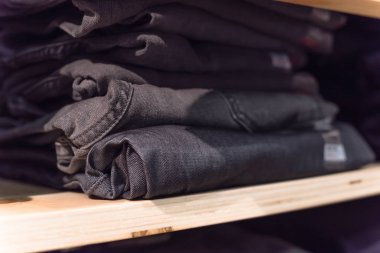 Amerika'da store kot giyim, yakın çekim yumuşak odak yığını. Şık denim Konfeksiyon, gündelik elbise tarzı mağaza raf raf