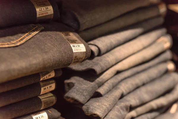 Amerika'da store kot giyim, yakın çekim yumuşak odak yığını. Şık denim Konfeksiyon, gündelik elbise tarzı mağaza raf raf