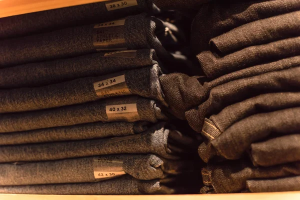 Amerika'da store kot giyim, yakın çekim yumuşak odak yığını. Şık denim Konfeksiyon, gündelik elbise tarzı mağaza raf raf