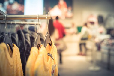 Seçici odak Trend Giyim Giyim Mağazası ile bulanık uzun kuyruk müşterinin ödeme kontuarında ağından beltline arkasında asılı