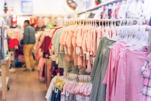 Soft focus, shallow DOF of baby clothing store in America with customer shopping